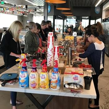 Carvana Co. - The People Ops team - as shown in this picture - preps fruit and waffles for everyone for Wacky Pants and Waffles Wednesdays.  Then the next morning brings ridiculous pants and a delicious smell to the office.