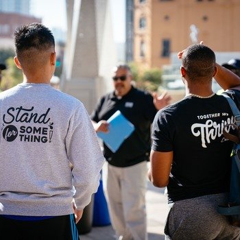 Classy - employees volunteering with shirts that read 'stand for something'