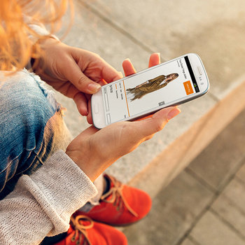Aptos Retail - Young woman using phone app with Aptos software