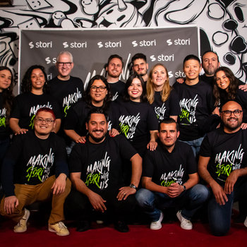 Stori - Group photo of Stori team members in front of a backdrop with Stori logo and graffiti art.