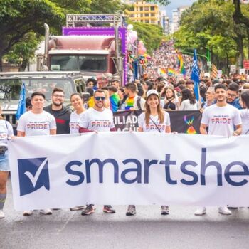 Smartsheet - A group of employees at the Pride parade in Costa Rica holding a banner that says Smartsheet.